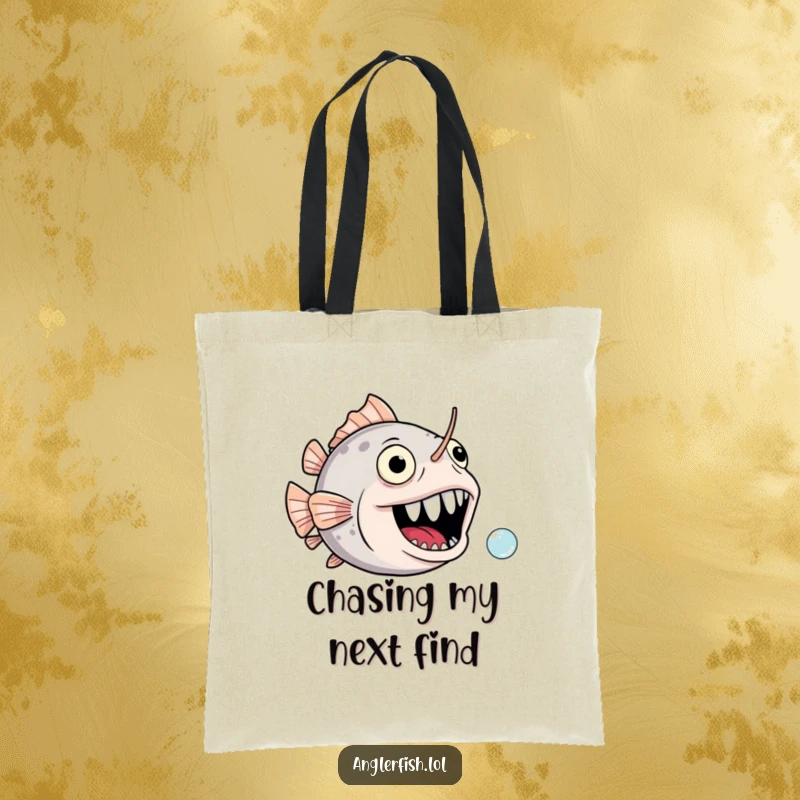 Funny anglerfish tote bag showcasing a gaping, joyful mouth comically chasing a tiny bubble, a picture of humorous delight.